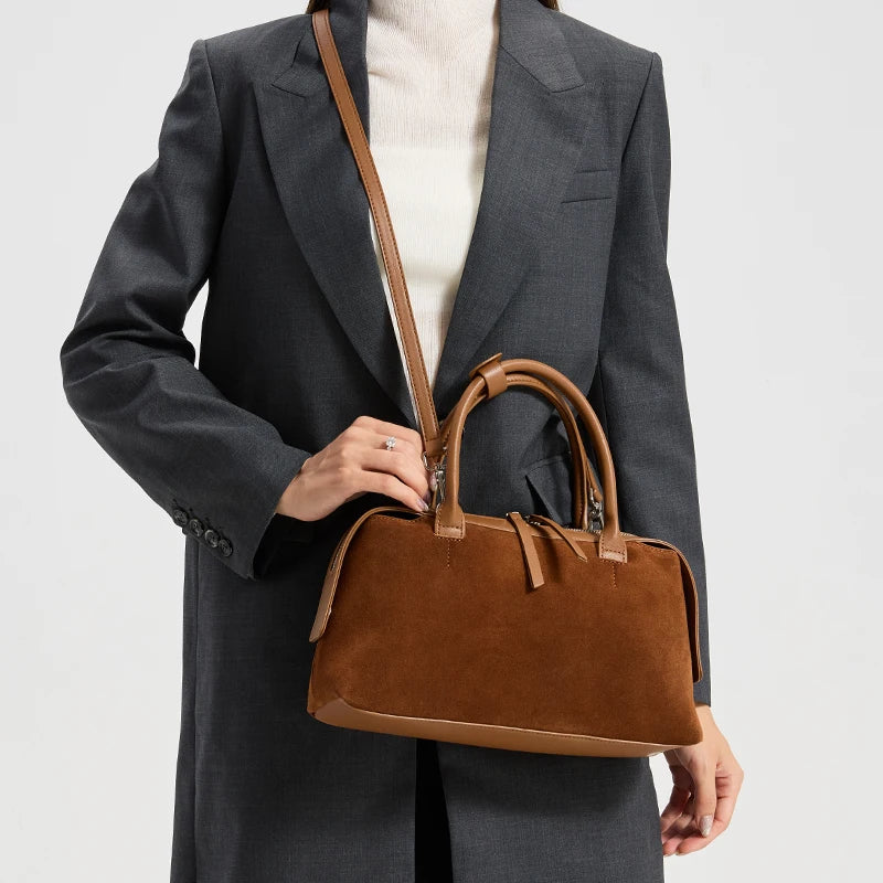 Sac à main en daim camel porté en bandoulière sur un manteau gris