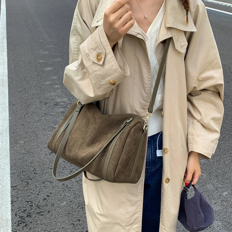 Femme portant le sac polochon kaki en bandoulière avec un trench