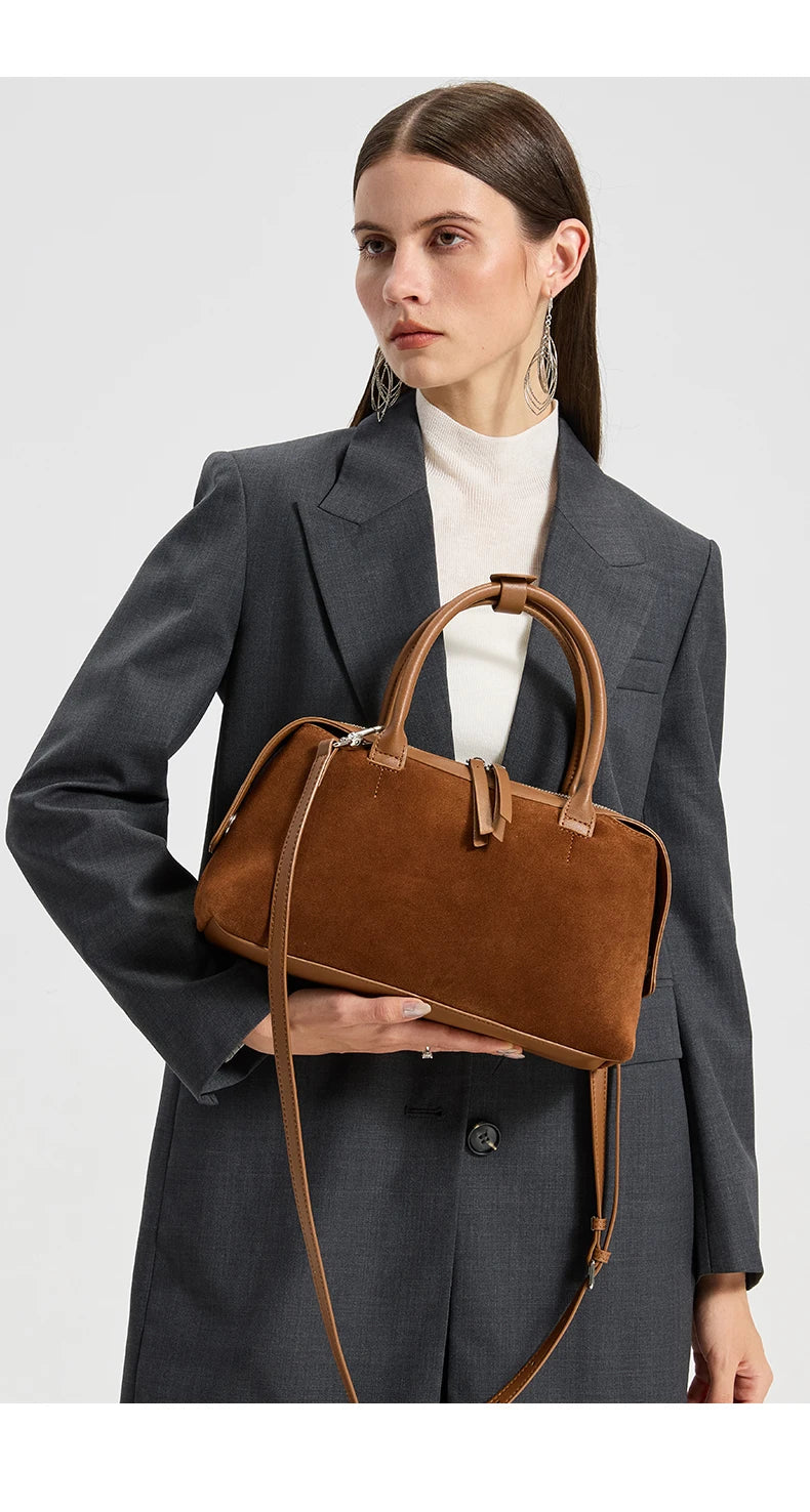 Mannequin portant le sac en daim camel avec un blazer gris