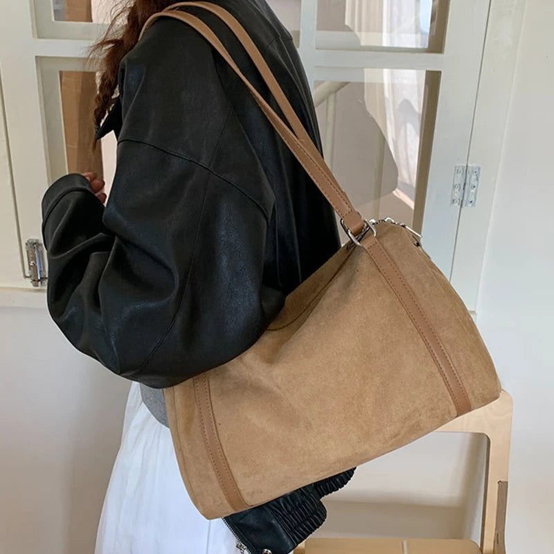 Sac polochon femme camel porté à l’épaule avec une veste en cuir