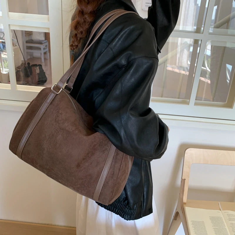 Sac polochon femme marron porté à l’épaule