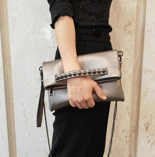 Pochette pour femme gris argenté tenue à la main