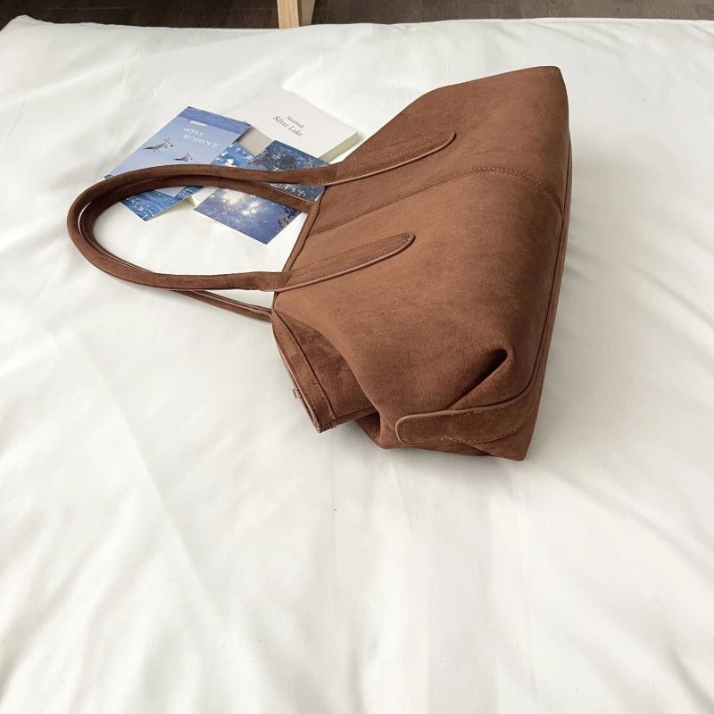 Sac suédine cognac posé à plat, vue de profil