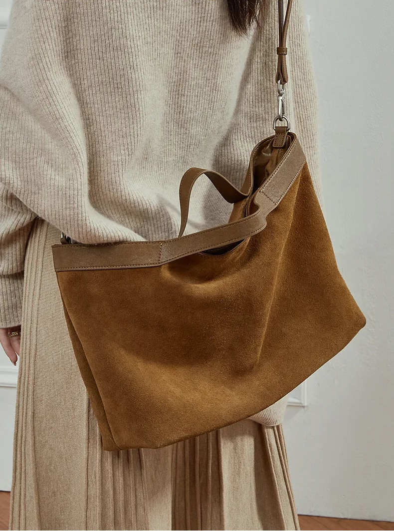 Femme portant le grand sac en daim cognac en bandoulière
