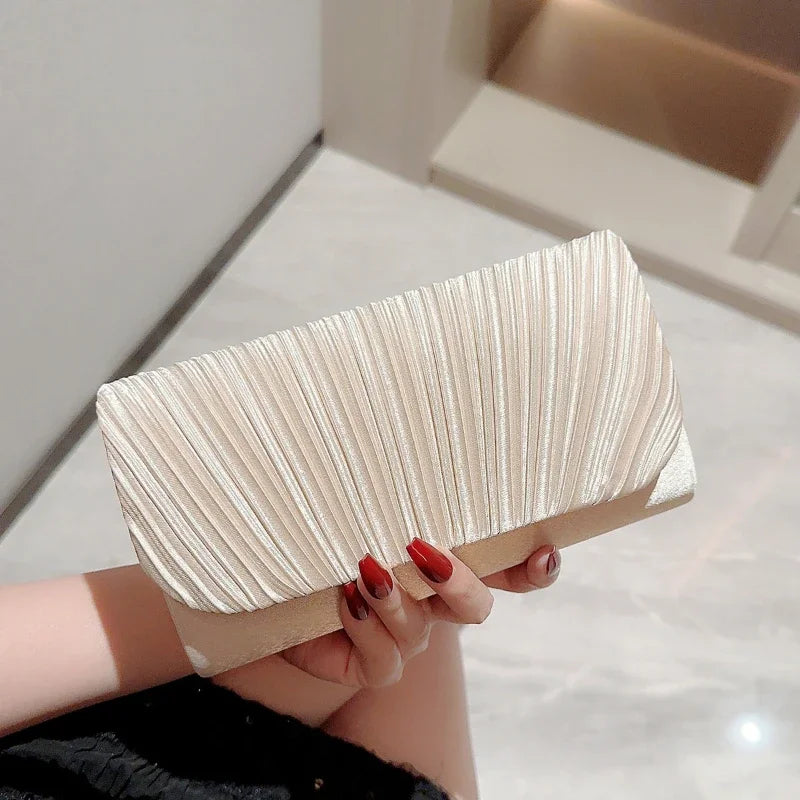 Pochette femme en satin plissé argenté tenue à la main