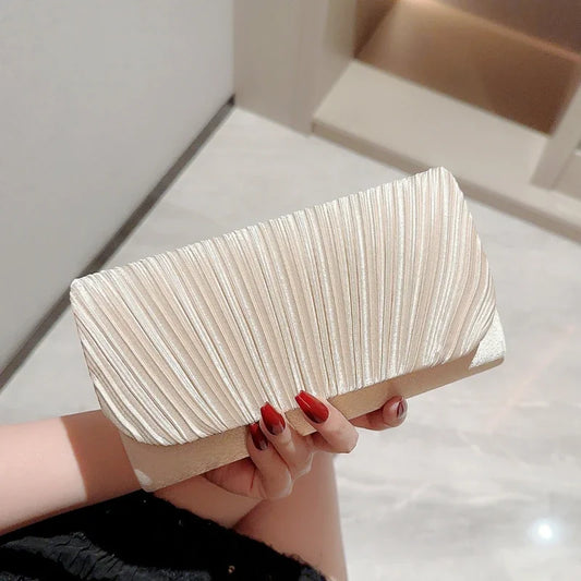 Pochette femme en satin plissé argenté tenue à la main
