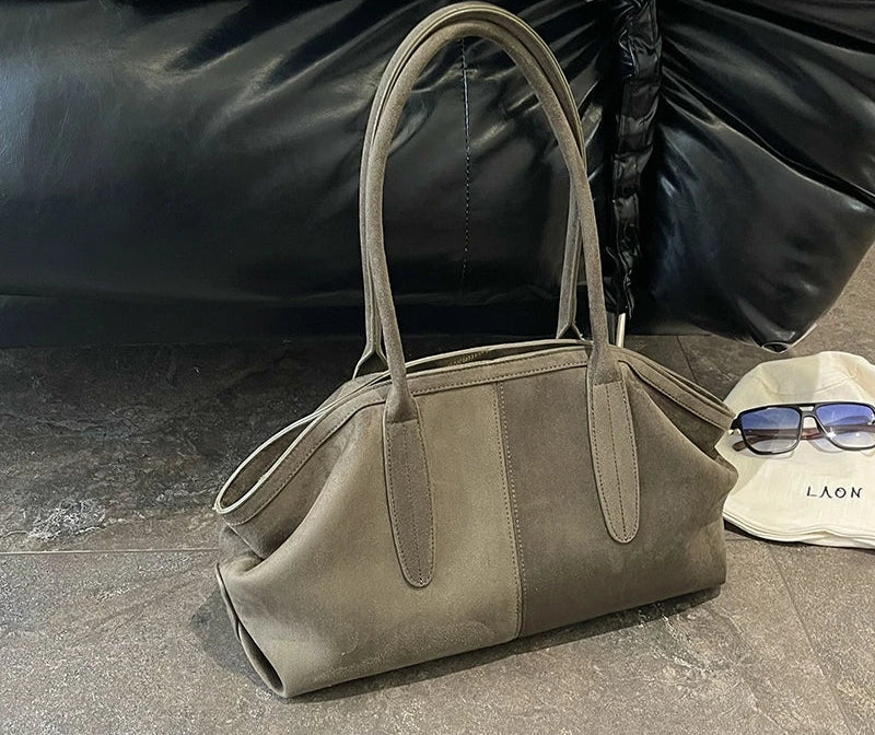 Sac suédine gris kaki posé au sol avec ses anses arrondies