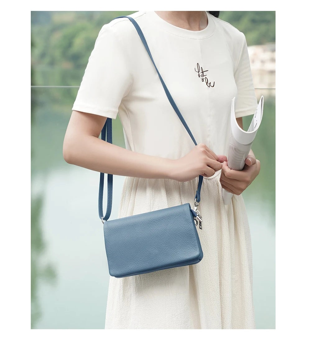 Pochette bandoulière en cuir bleu lin portée épaule