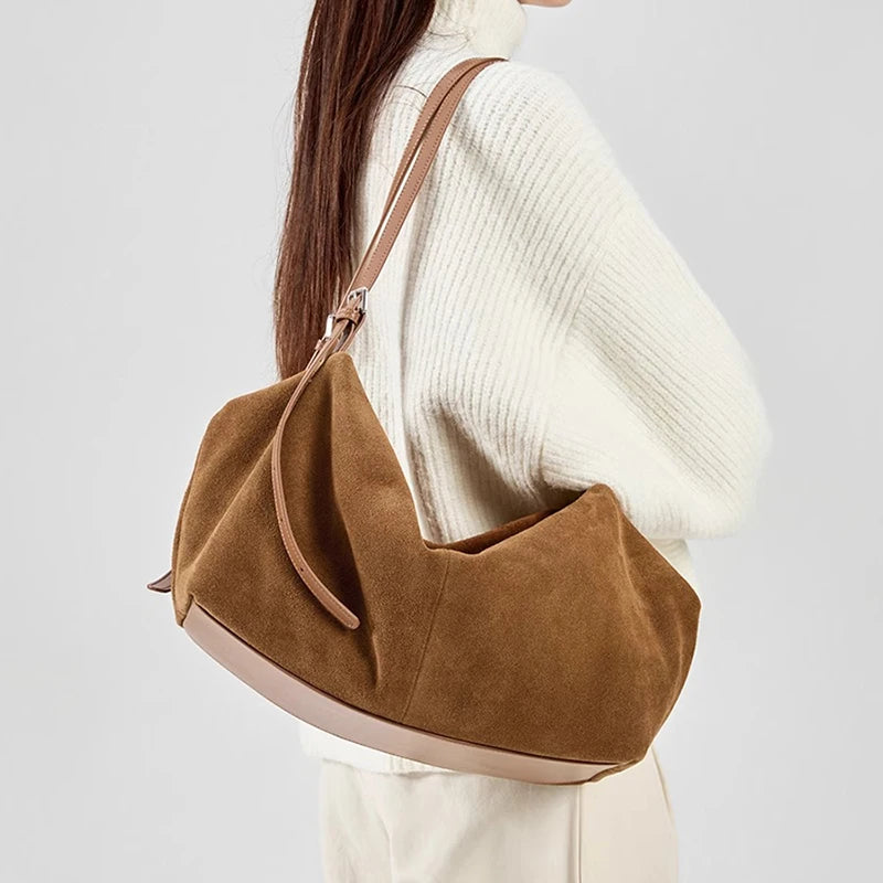 Sac à main en daim camel porté avec une tenue écrue