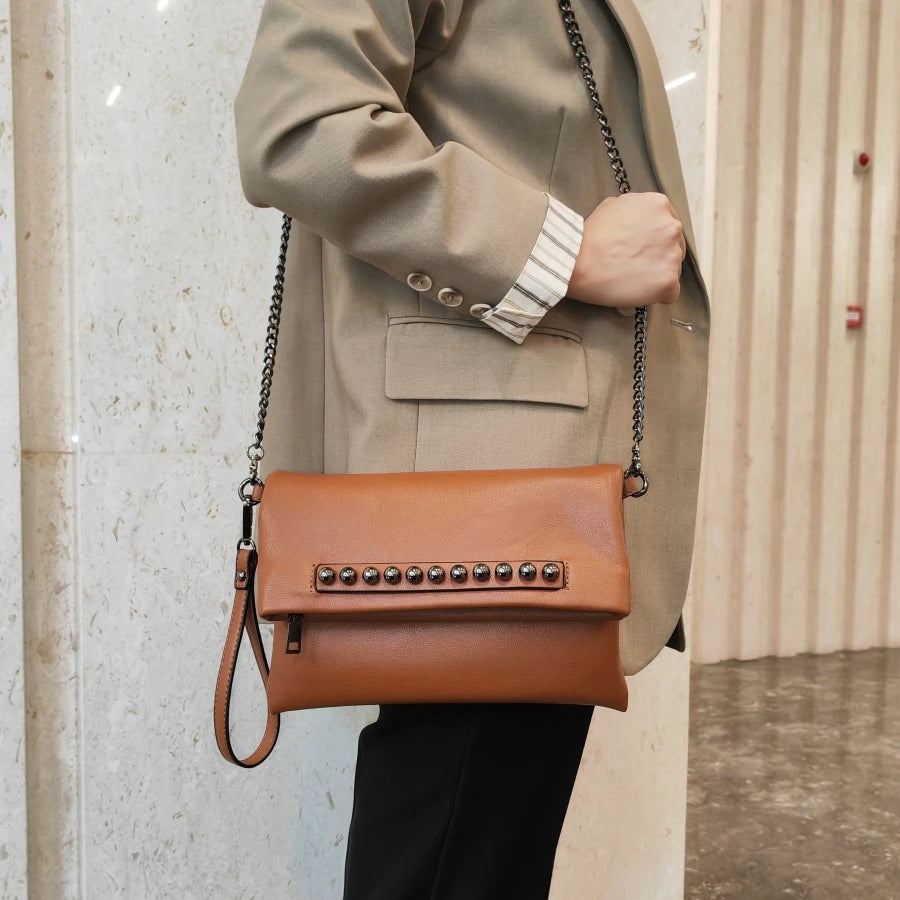 Pochette pour femme marron portée en bandoulière avec un blazer